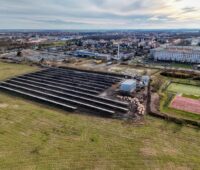 Luftbild zeigt Solarthermieanlage am Rande einer Gemeinde.