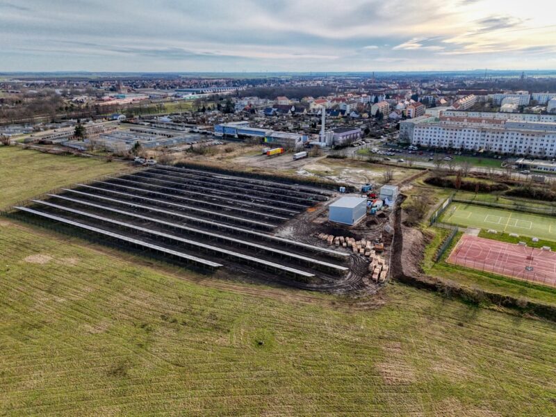 Luftbild zeigt Solarthermieanlage am Rande einer Gemeinde.