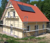 Haus eingerüstet, Baustelle, mit Solarthermie-Anlage