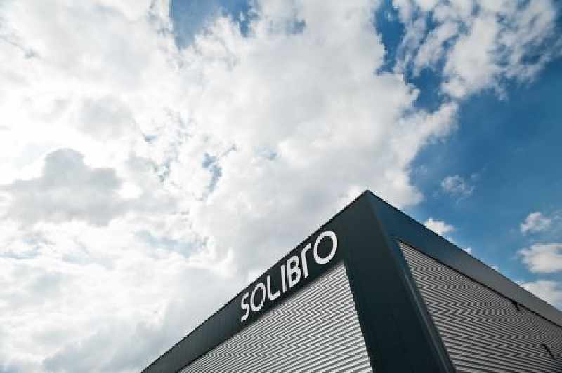 Gebäudeecke unter blauem Himmel mit Firmenschriftzug Solibro
