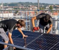 Im Bild zwei Männer, die für die Stadtwerke Stuttgart eine Photovoltaik-Anlage installieren.