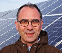 Portrait Sven Neunsinger vor Photovoltaik-Freiflächenanlage in Tunesien.