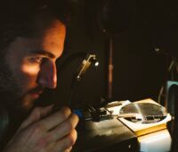 Ein Wissenschaftler betrachtet eine beleuchtete Solarzelle.