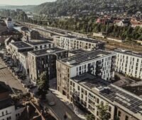 Zu sehen ist eine Luftaufnahme vom Klimaquartier Neue Weststadt in Esslingen mit Photovoltaik-Anlagen auf den Dächern der Gebäude.