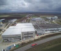 Luftbild neuer Fabrikgebäude in einem Gewerbegebiet an der Autobahn.