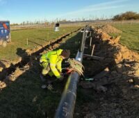 Arbeiter bei der Verlegung von Rohrleitungen für eine große Solarthermieanlage.