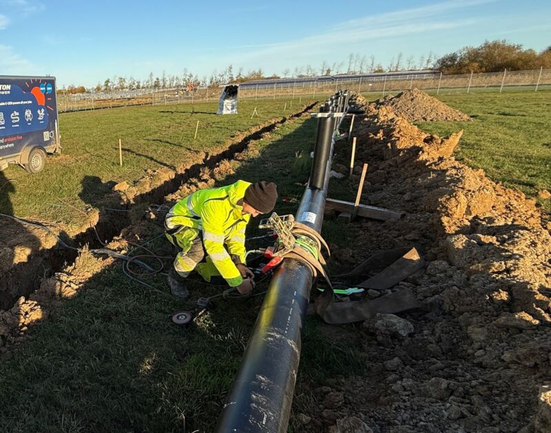 Arbeiter bei der Verlegung von Rohrleitungen für eine große Solarthermieanlage.