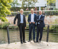 Die drei Vorstandsmitglieder der Umweltbank an einem Fluss
