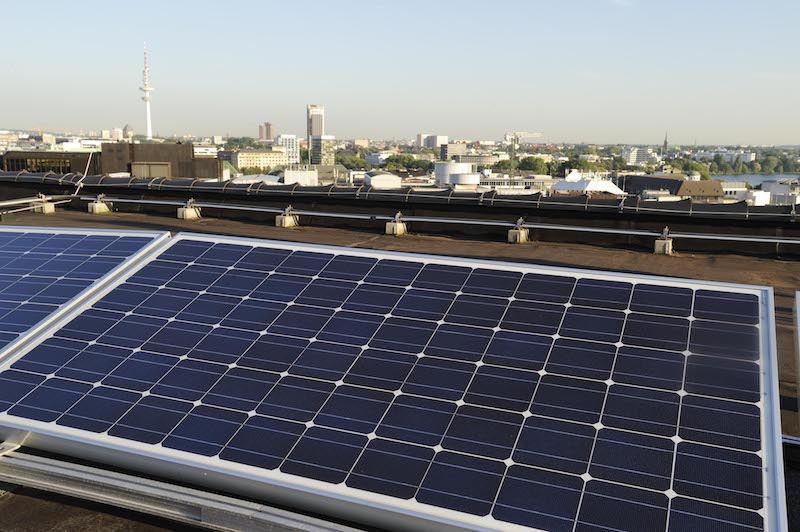 Photovoltaikanlage im Vordergrund, im Hintergrund die Skyline von Hamburg