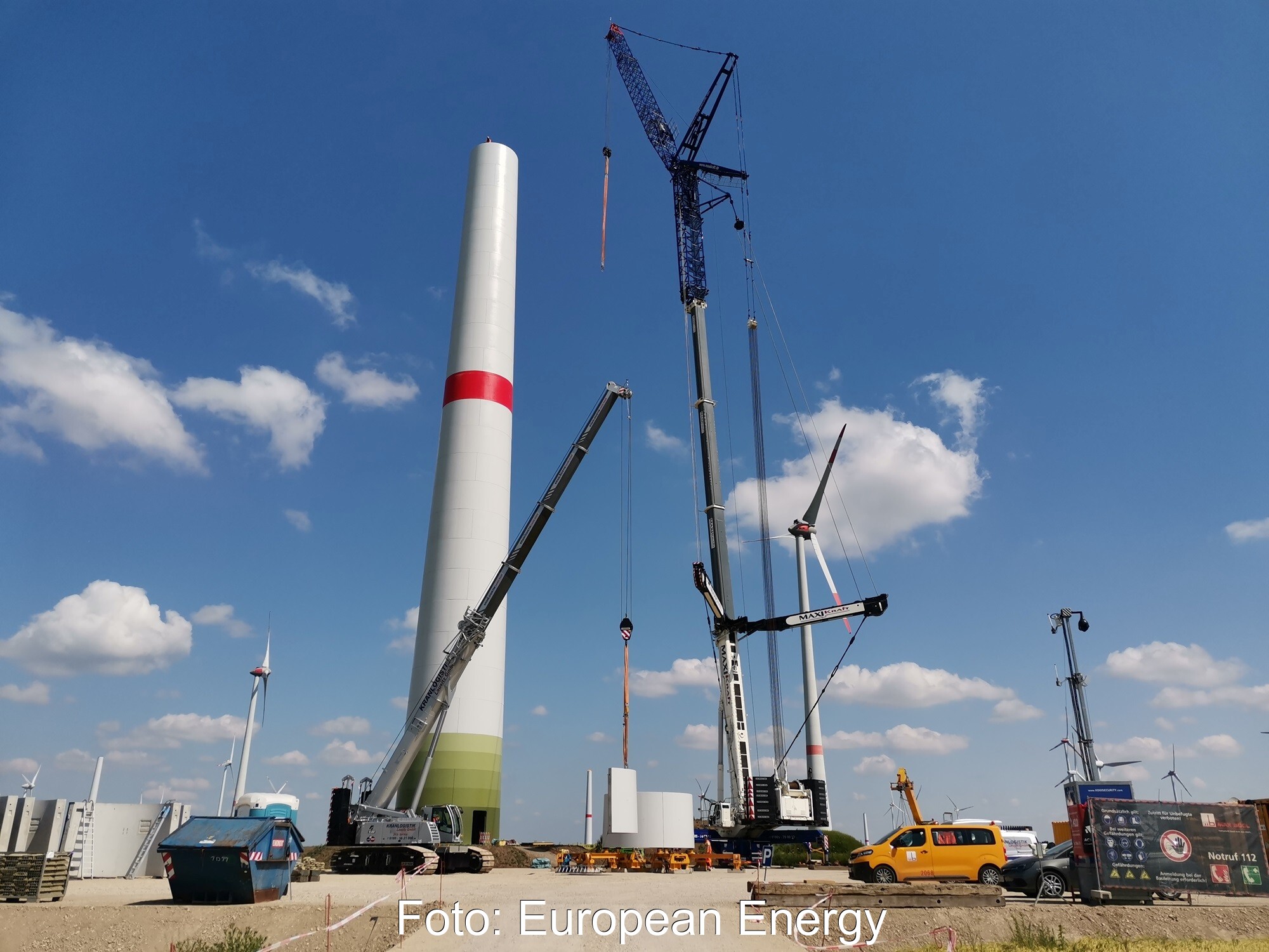 Ein Kran neben dem Turm einer Windenergie-Anlage - Repowering eines Windparks im Burgenlandkreis.