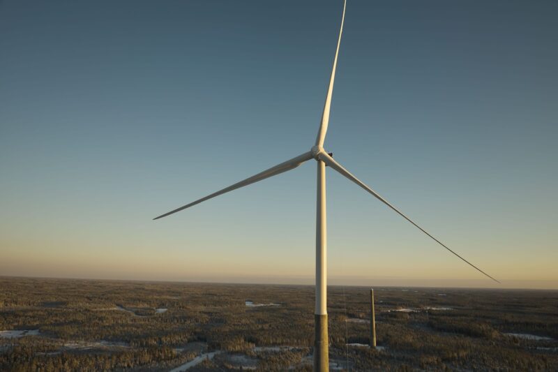 Foto von Windturbine mit Hybridturm von Nordex - man erkennt den unteren Teil des Turms aus Beton in grau, den oberen aus Stahl in weiß.