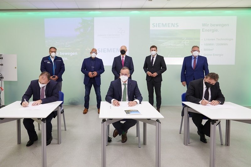 Zu sehen ist die Unterzeichnung der Absichtserklärung für den Lithium-Ionen-Batteriespeicher mit 200 Megawattstunden Speicherkapazität, den Siemens Smart Infrastructure in Wunsiedel errichten soll.