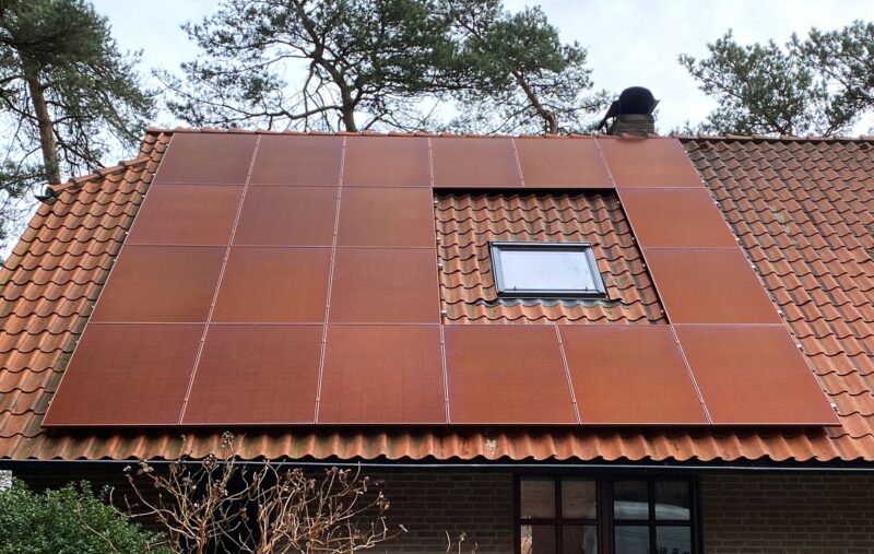 Im Bild ein Dach mit roten Photovoltaik-Modulen, Greenakku bietet farbige Photovoltaik-Module an.