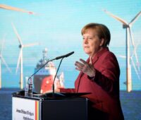 Bundeskanzlerin Angela Merkel mit Offshore-Windpark im Hintergrund