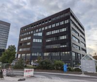 Bürogebäude mit einer Fassade und integrierten Photovoltaik-Modulen.