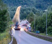 Transport eines Rotorblattes für Windturbine über eine Landstrasse mit Schaulustigen.