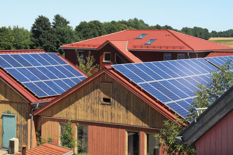 Dächer mehrerer Gebäude mit Solarstromanlagen belegt.