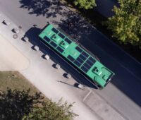 Luftbild zeigt einen Bus von oben mit Photovoltaikmodulen auf dem Dach.