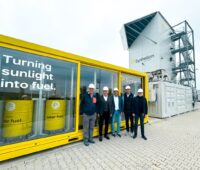 Fünf Männe vor der Pilotanlage zur Herstellung von Solarkraftstoff in Jülich.