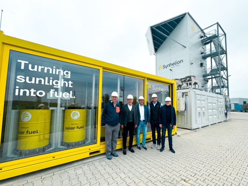 Fünf Männe vor der Pilotanlage zur Herstellung von Solarkraftstoff in Jülich.