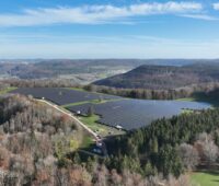 Luftbild eines PV-Parks von Hügeln umgeben.